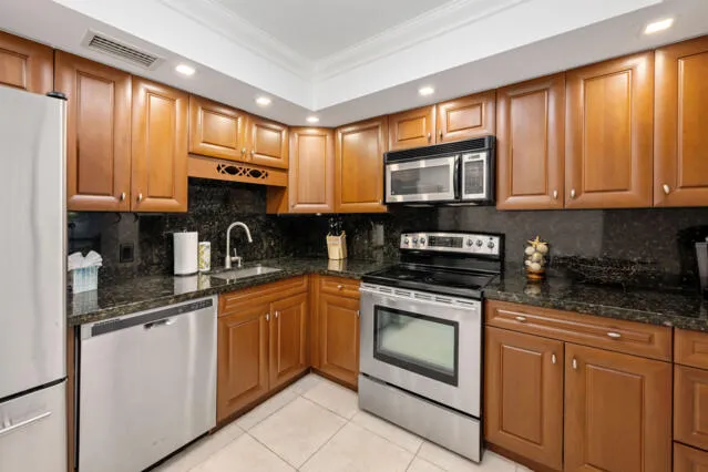 a bathroom with a granite countertop sink a toilet and shower