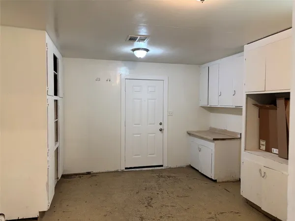a kitchen with granite countertop a stove a sink and a refrigerator