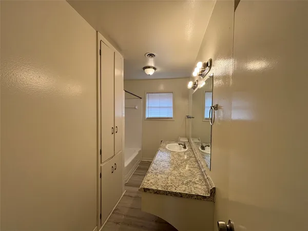 a bathroom with a granite countertop sink and a mirror