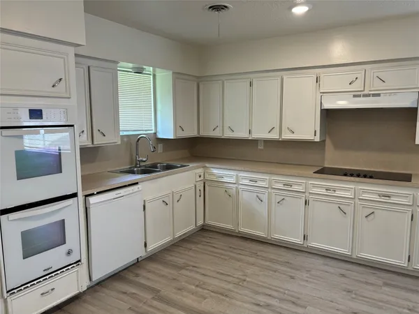 a kitchen with granite countertop white cabinets and white appliances