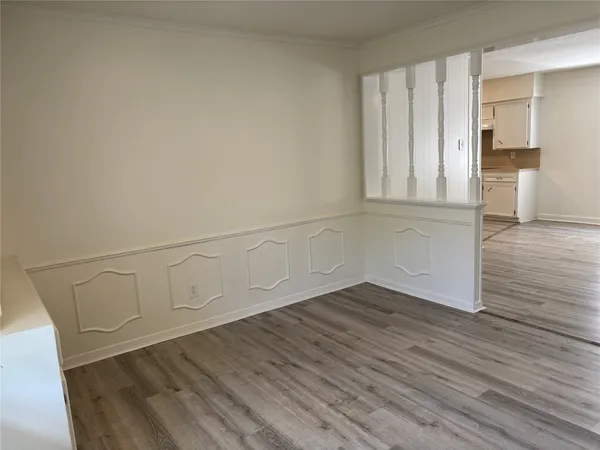 a view of an empty room with wooden floor