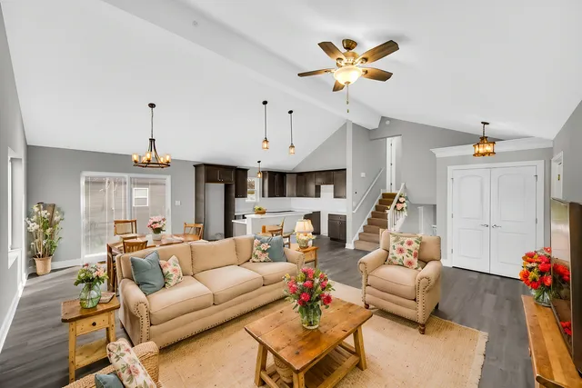 a living room with furniture kitchen view and a chandelier