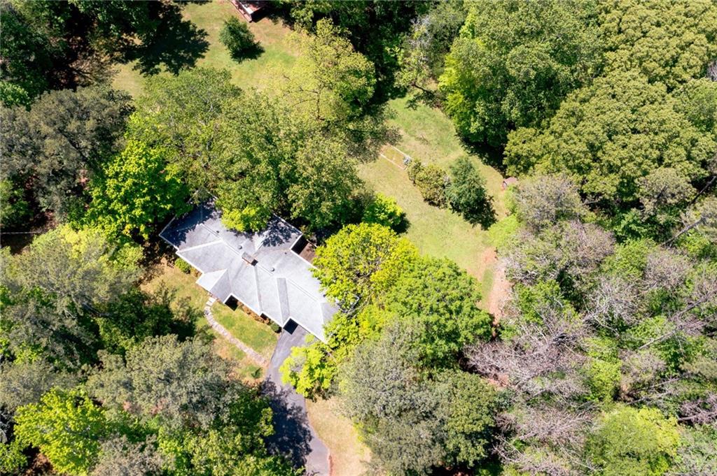 an aerial view of residential house with trees all around