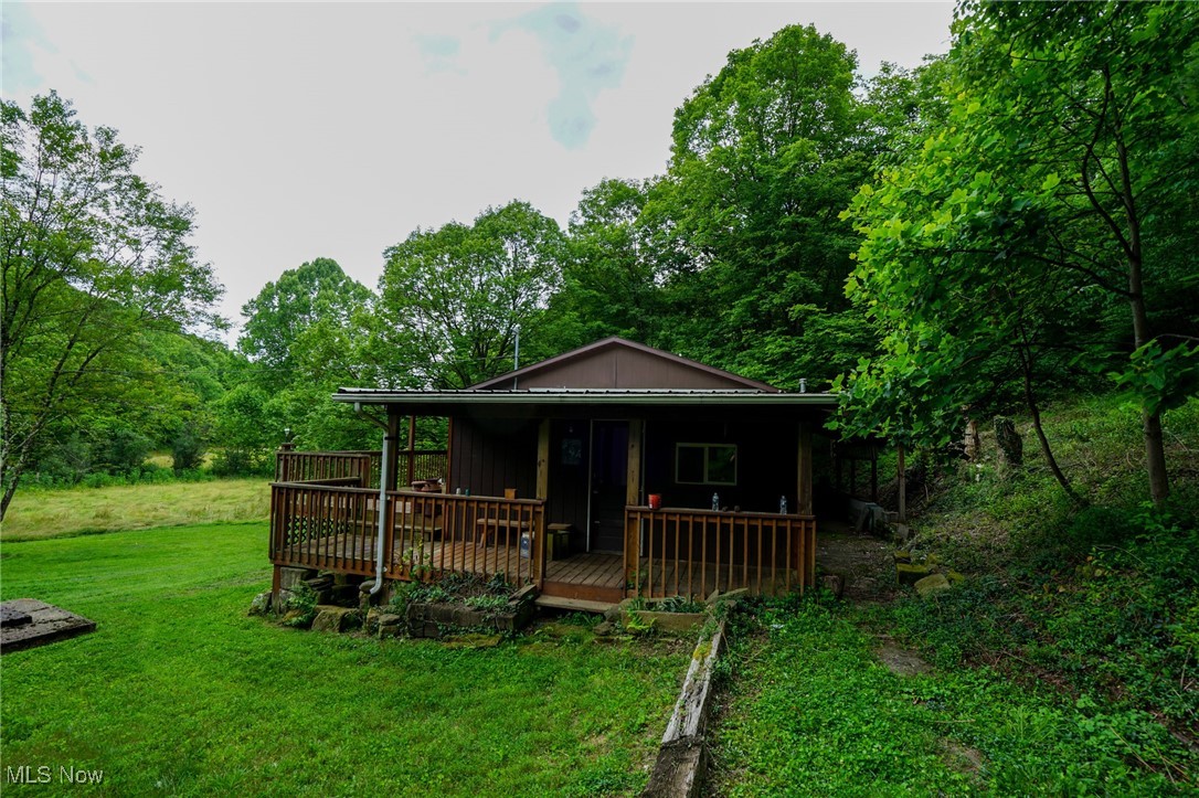 34799 Paw Road Lower Salem, OH 45745 - Photo 14 of 50 Back of house featuring a lawn, view of wooded area, board and batten siding, and a wooden deck