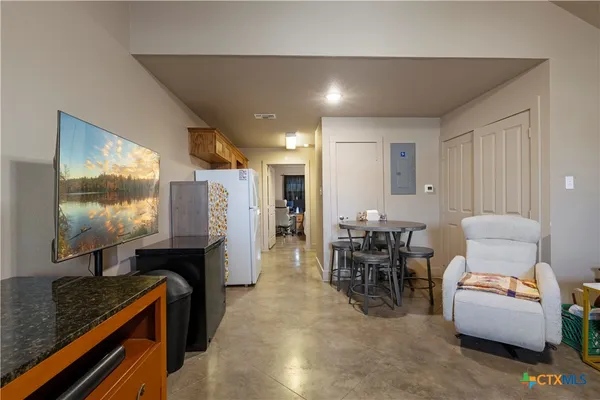 a dining room with furniture and a flat screen tv