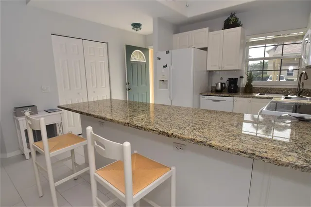a kitchen with stainless steel appliances granite countertop a sink refrigerator and cabinets