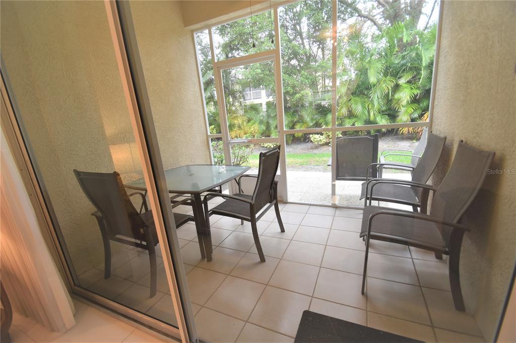 4235 Castle Bridge, Unit 1216 Sarasota, FL 34238 - Photo 5 of 18 a view of a dining room with furniture and large windows
