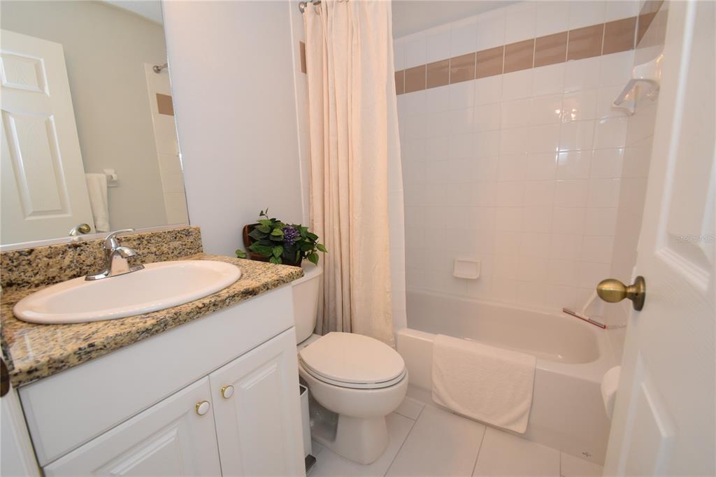 4235 Castle Bridge, Unit 1216 Sarasota, FL 34238 - Photo 9 of 18 a bathroom with a granite countertop sink a toilet and shower