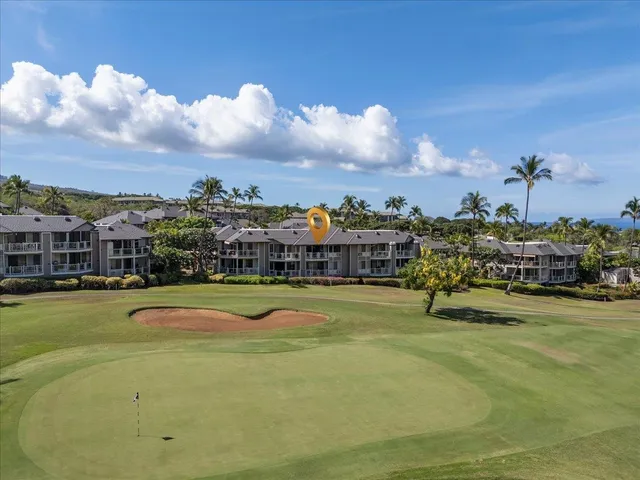 a living room with couch chandelier and a dining table with wooden floor