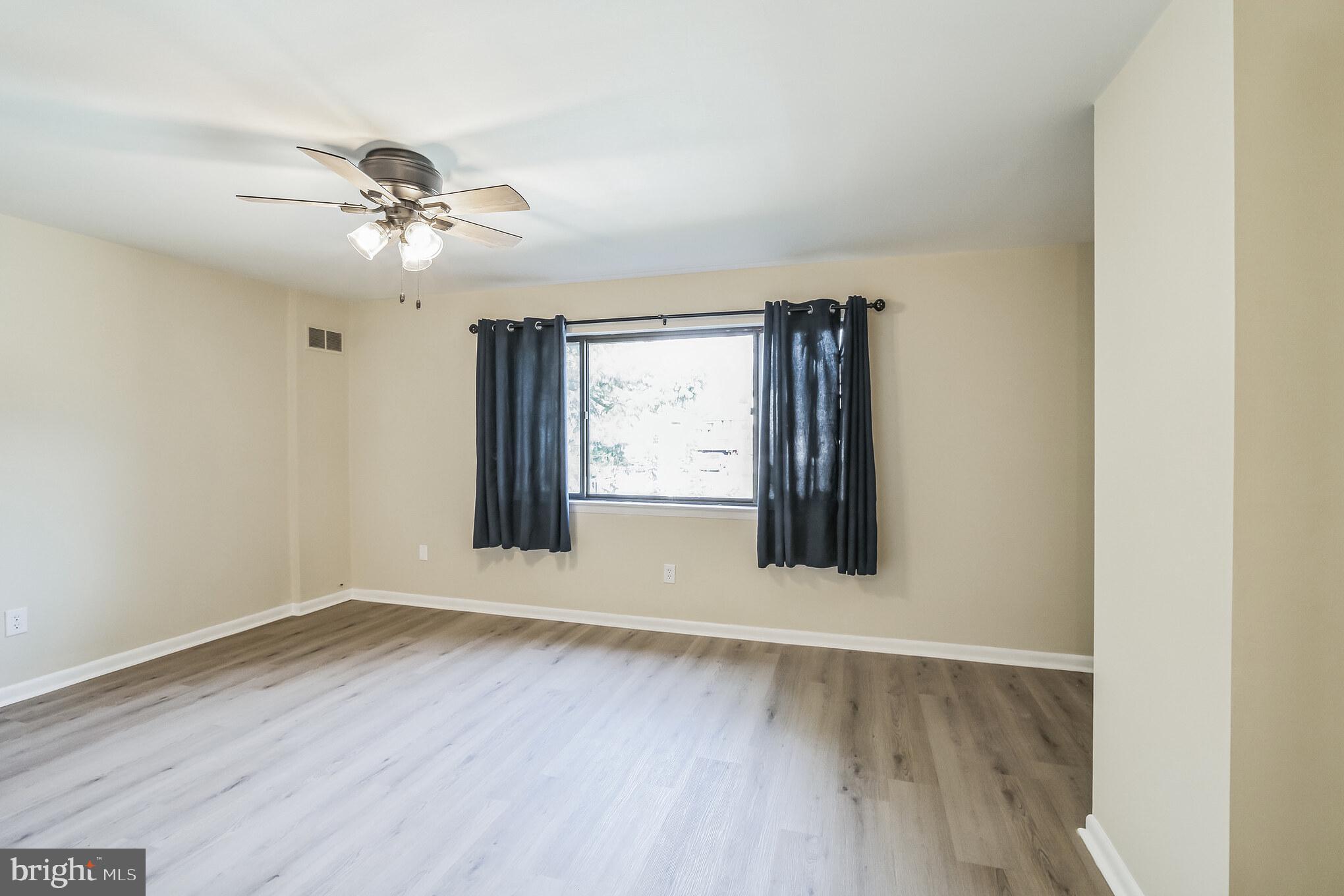 1179 Putnam Boulevard, Unit 3 Wallingford, PA 19086 - Photo 8 of 9 a view of an empty room with wooden floor and a window