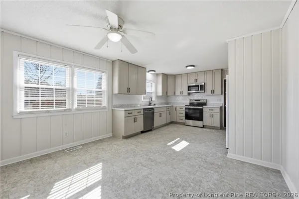 a open kitchen with cabinets a sink and appliances