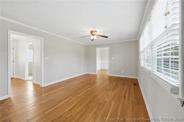 a view of a livingroom with wooden floor and a ceiling fan