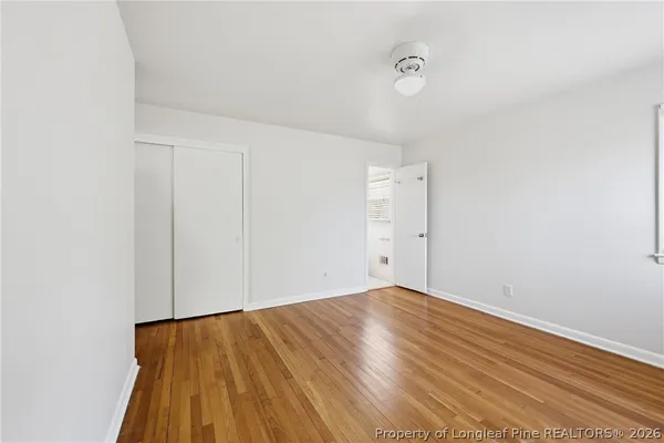 a view of an empty room with wooden floor
