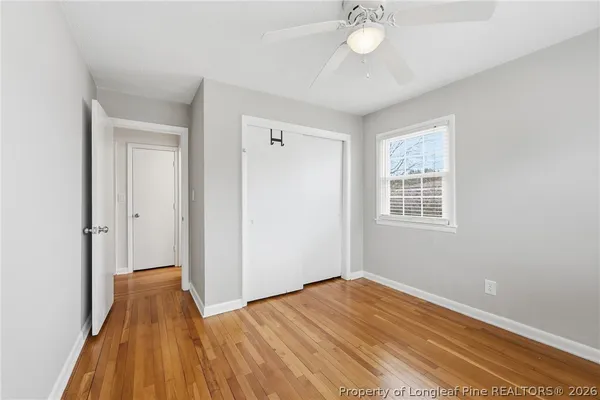 a view of a room with wooden floor and fan