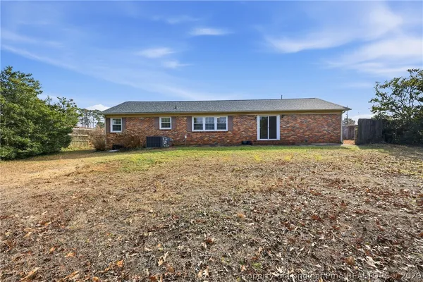 a view of a house with a yard and a large tree