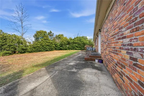 a view of a yard with potted plants and wooden fence