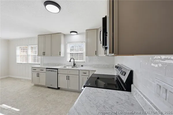 a kitchen that has a sink and a stove in it