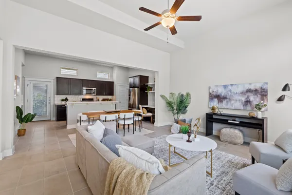 a living room with furniture and a view of kitchen