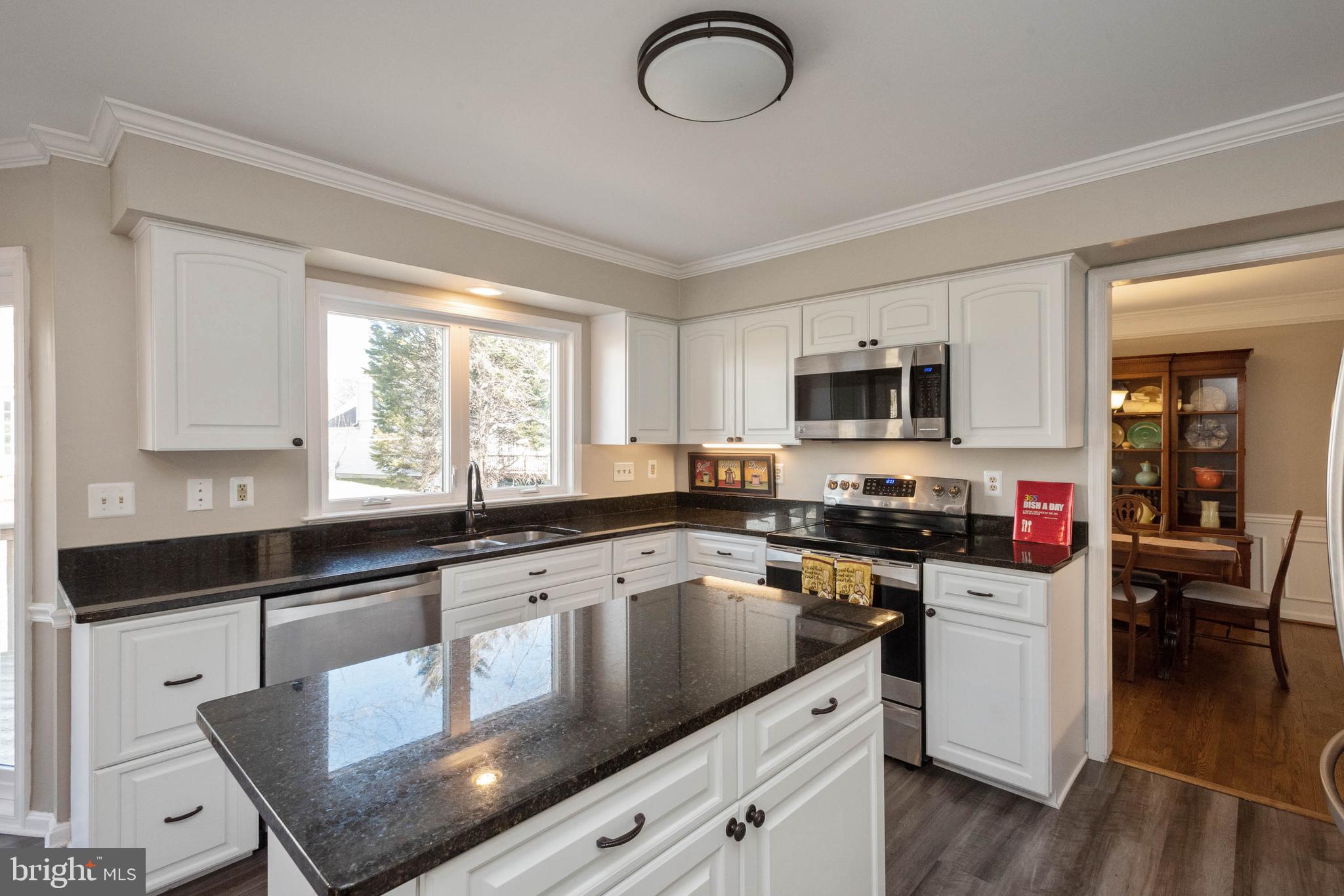 8608 Ashcroft Drive Laurel, MD 20708 - Photo 11 of 45 a kitchen with stainless steel appliances granite countertop a sink dishwasher stove and microwave with wooden floor