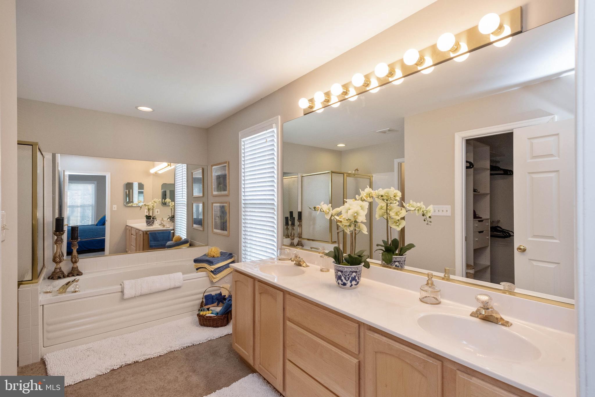 8608 Ashcroft Drive Laurel, MD 20708 - Photo 23 of 45 a bathroom with double vanity sinks a large mirror and a shower