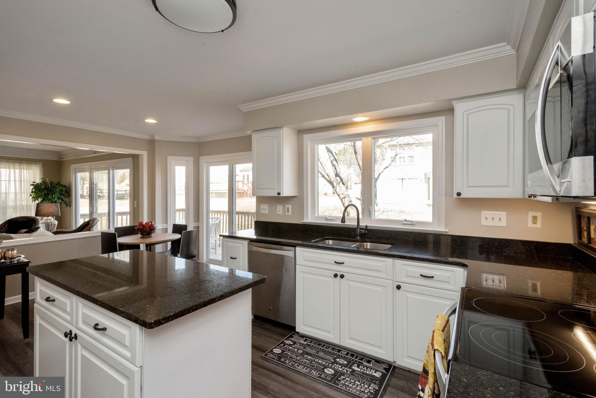 8608 Ashcroft Drive Laurel, MD 20708 - Photo 8 of 45 a kitchen with granite countertop a sink a stove cabinets and living room