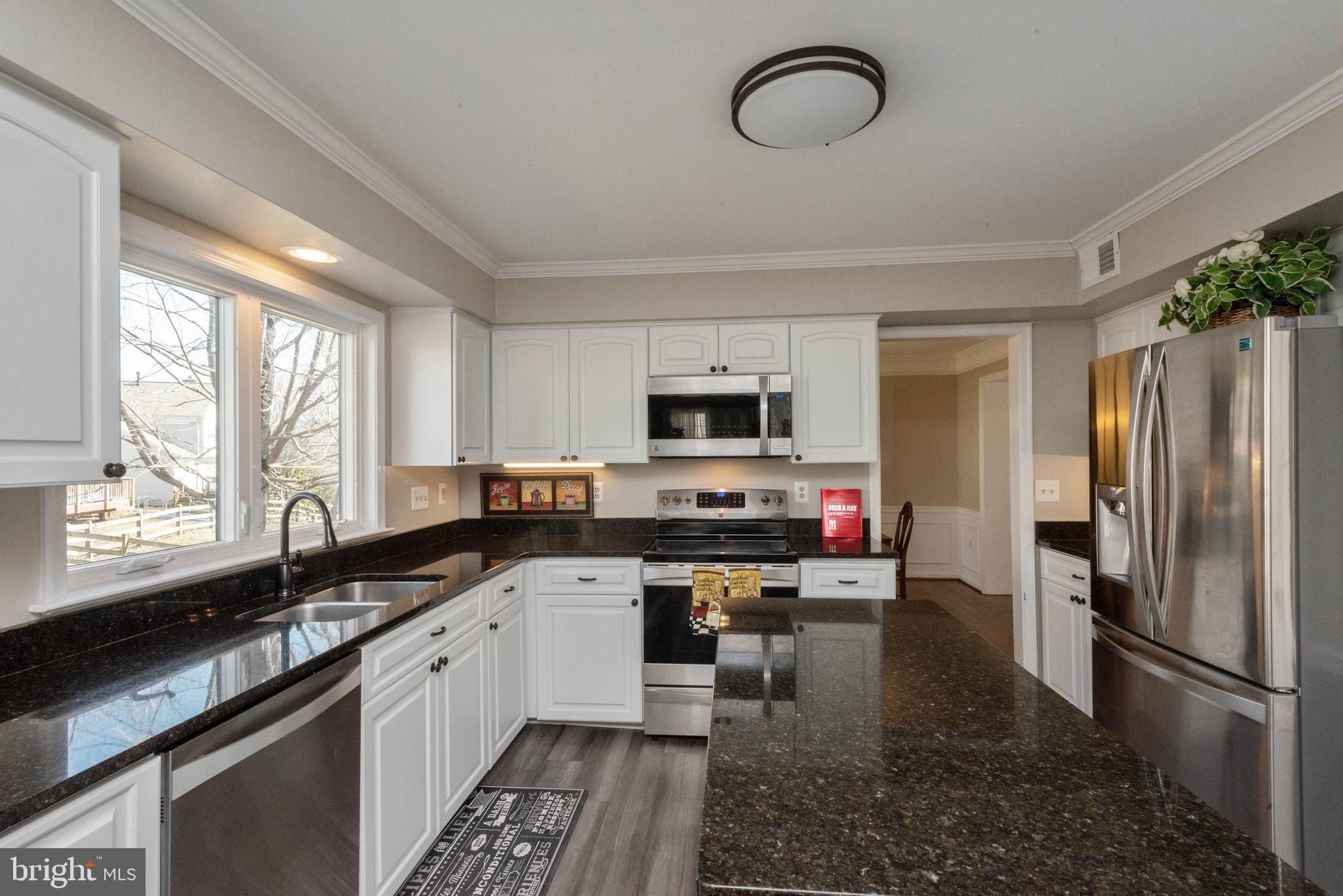 8608 Ashcroft Drive Laurel, MD 20708 - Photo 10 of 45 a kitchen with stainless steel appliances granite countertop a sink a stove a refrigerator cabinets and a window
