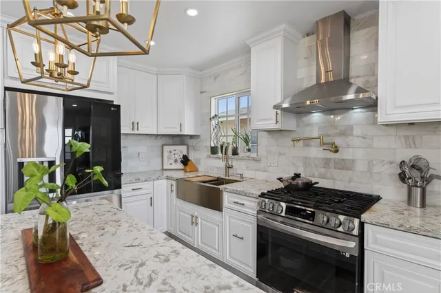 a kitchen with stainless steel appliances granite countertop a sink stove and cabinets