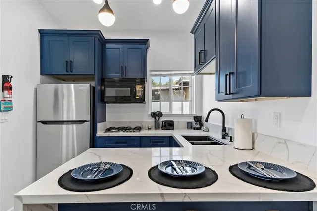 a kitchen with stainless steel appliances a sink a stove a refrigerator and cabinets