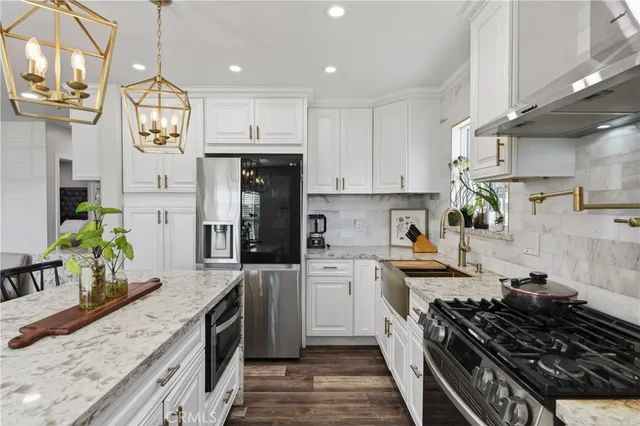 a kitchen with stainless steel appliances a stove a sink a refrigerator and cabinets