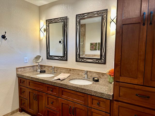 a bathroom with a granite countertop sink and a mirror