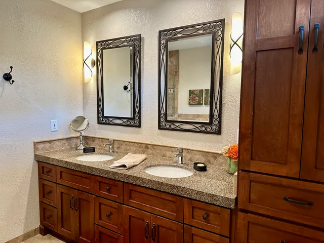 a bathroom with a granite countertop sink and a mirror
