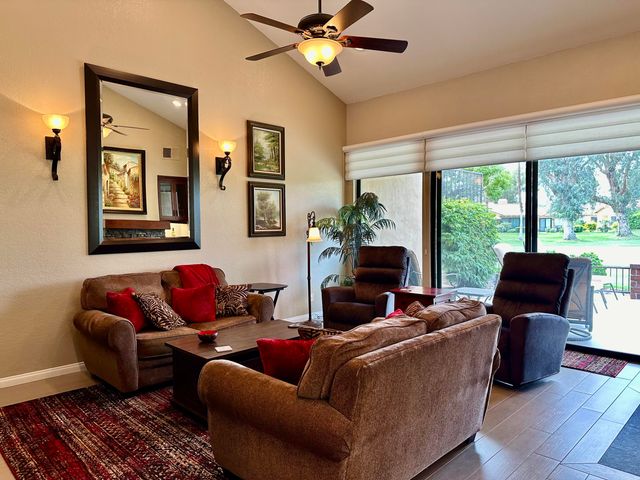 a living room with furniture a floor to ceiling window and a flat screen tv