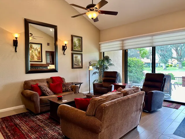 a living room with furniture a floor to ceiling window and a flat screen tv