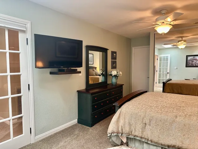 a bedroom with a bed and a flat tv screen on wall