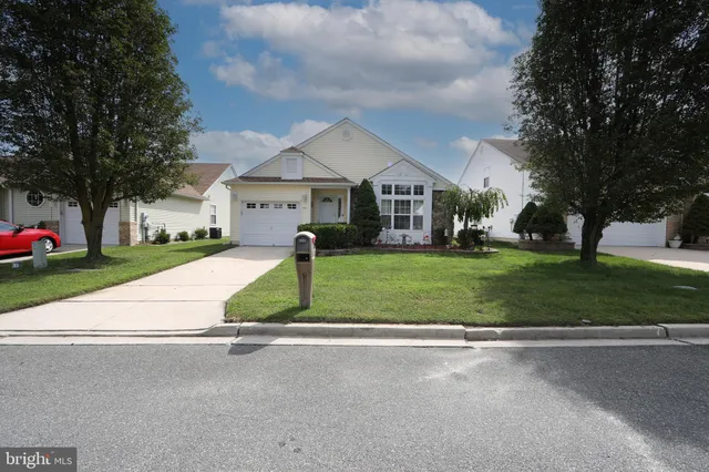 a front view of a house with a yard and trees
