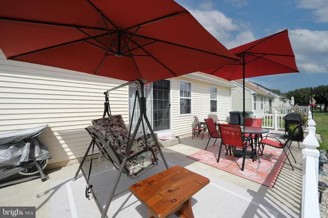 a view of a patio with a dining table and chairs under an umbrella