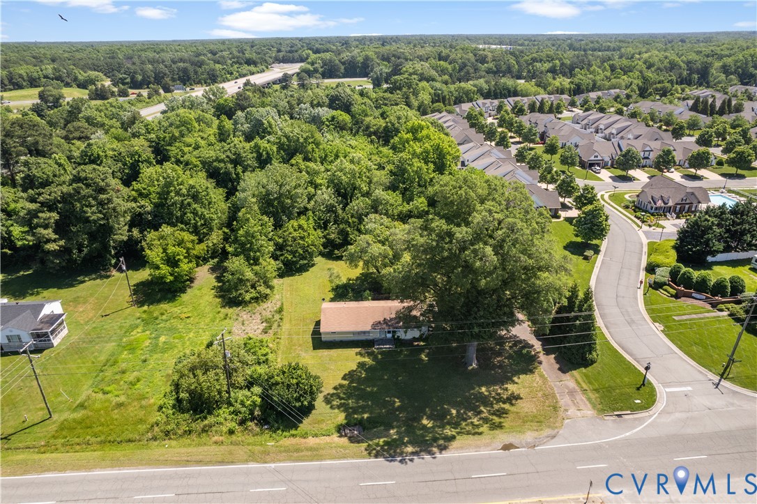an aerial view of residential houses with outdoor space and trees