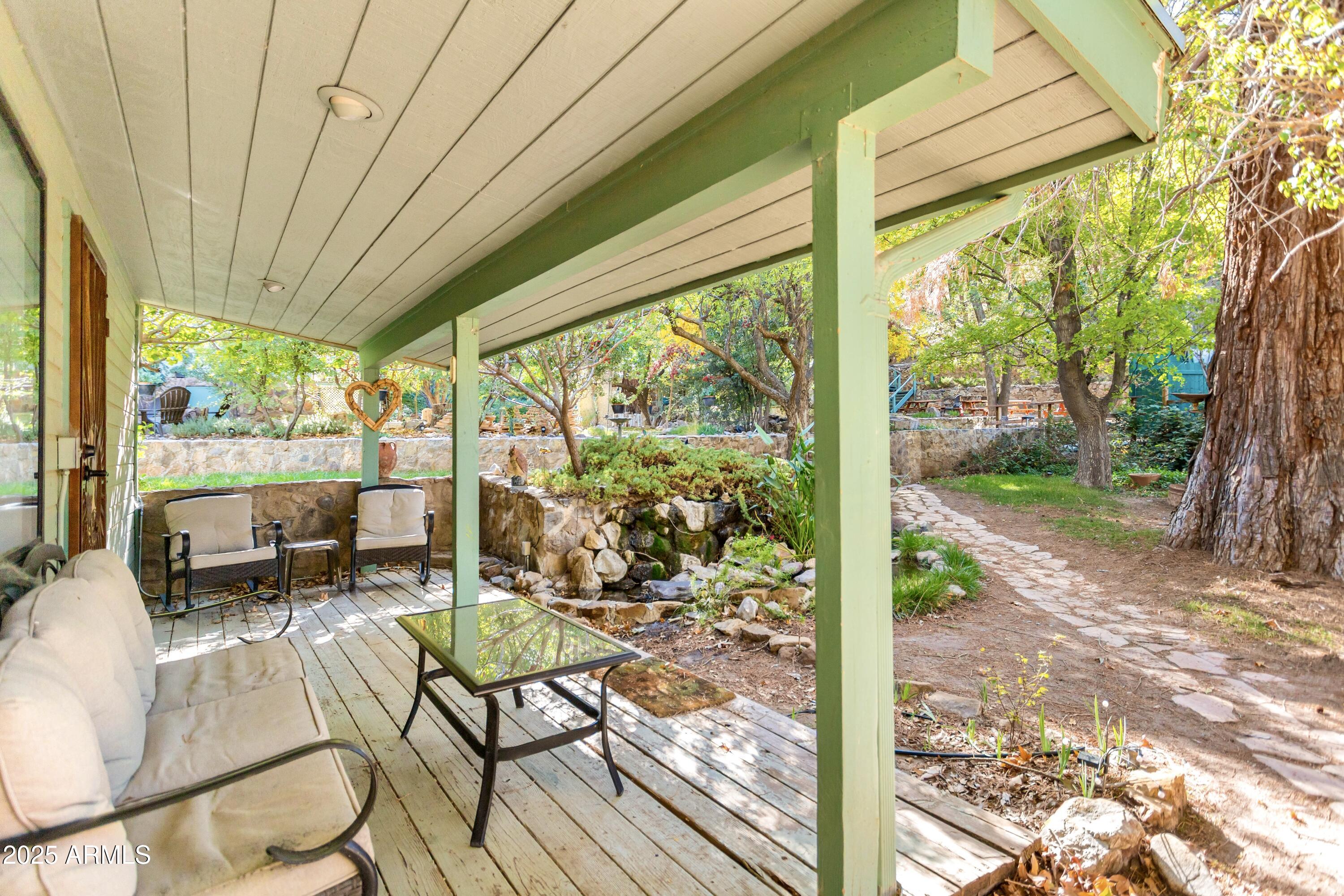 29 East Ramsey Canyon Road Hereford, AZ 85615 - Photo 103 of 119 a view of a patio with table and chairs potted plants with wooden floor and fence