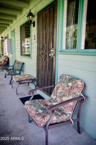 a view of a patio with table and chairs potted plants with wooden floor and fence