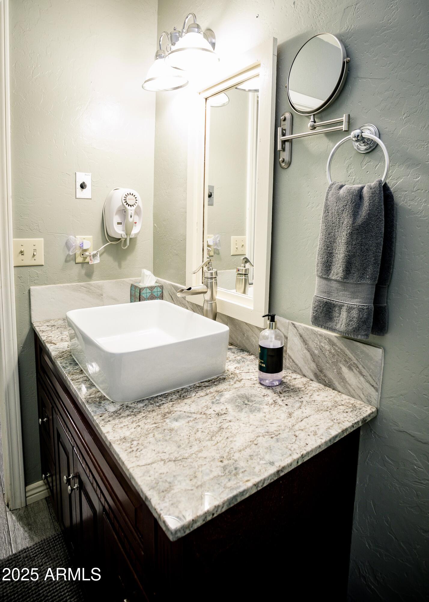 29 East Ramsey Canyon Road Hereford, AZ 85615 - Photo 55 of 119 a bathroom with a granite countertop sink a toilet and a mirror