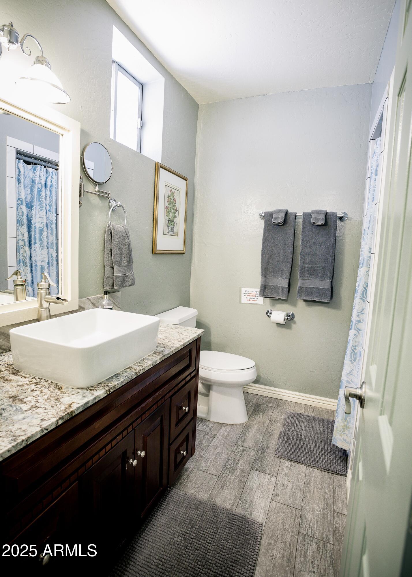 29 East Ramsey Canyon Road Hereford, AZ 85615 - Photo 56 of 119 a bathroom with a granite countertop sink a toilet and a mirror