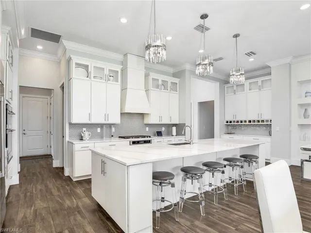a kitchen that has a lot of cabinets in it and wooden floors