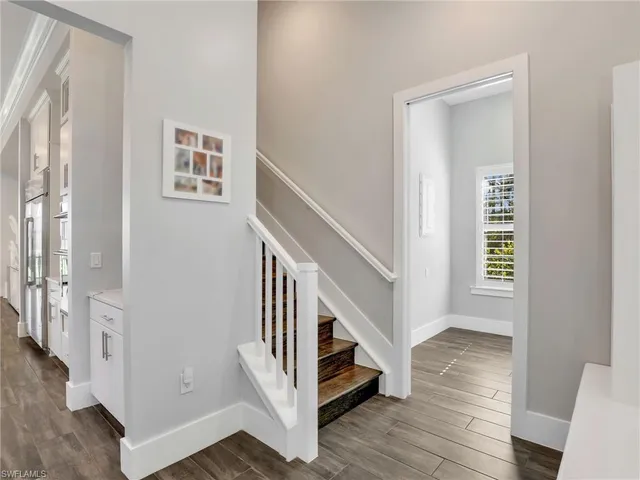 a view of a hallway with wooden floor and stairs