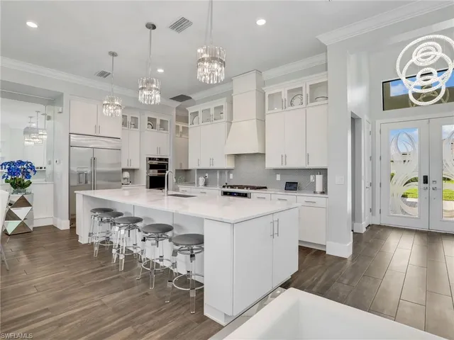 a kitchen with kitchen island granite countertop a sink cabinets and wooden floor