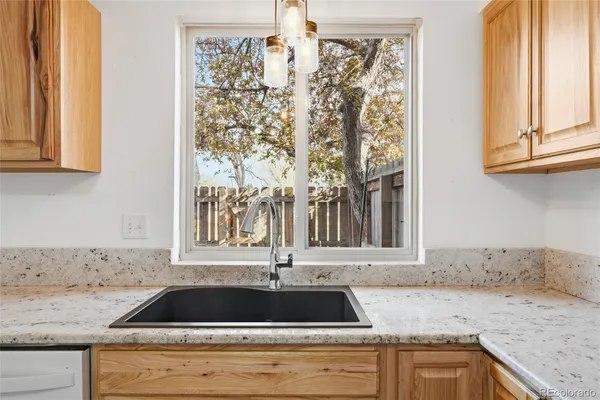 a kitchen with a granite countertop sink and window