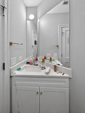 a bathroom with a sink vanity and a mirror