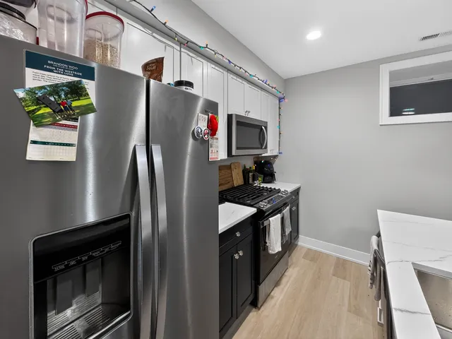 a kitchen with stainless steel appliances granite countertop a refrigerator a stove a sink and a microwave