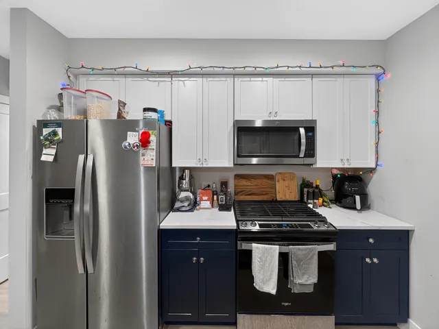 a kitchen with a refrigerator and a stove top oven