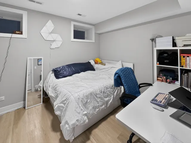 a bedroom with two beds and a desk