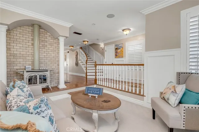 a living room with furniture large window and wooden floor